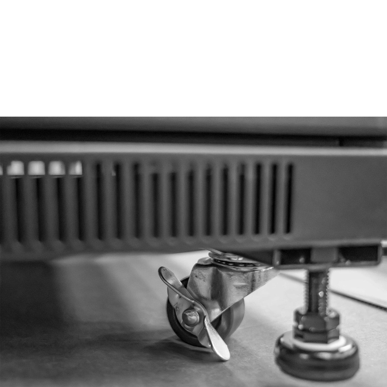 Bottom corner part of a 22U Floor Standing Data Cabinet showing its castor wheel and a jacking feet.