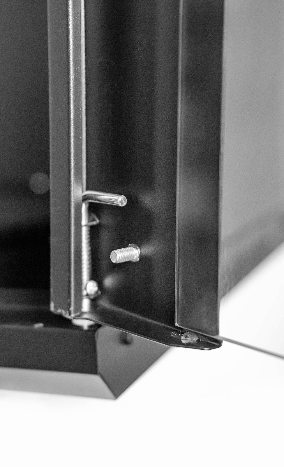 The glass door panel's bottom hinge of aflat-packed 9U 450mm Deep Wall Mount Data Cabinet.